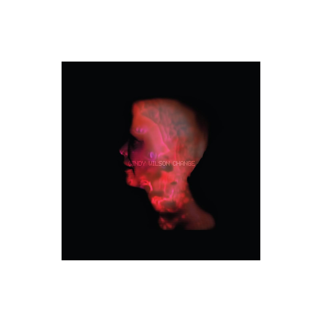 A glowing red and purple translucent skull silhouette on black background on the cindy wilson change cd cover by b-52s