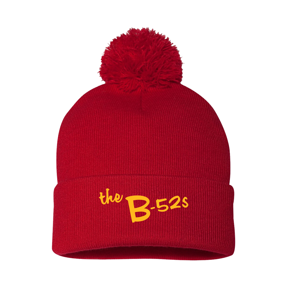 Red knit beanie with a pom-pom and ’the B-52s’ written in yellow.